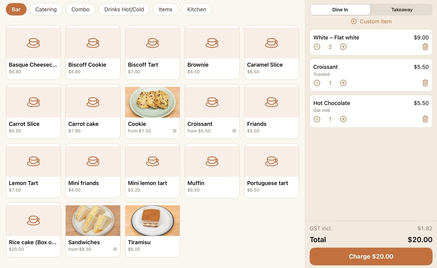 The till sell screen on iPad — the menu grid beside an in-progress order of flat whites, a croissant and a hot chocolate, ready to charge